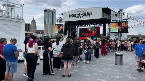 Crowd Lines Up for Outdoor Event on Rooftop Stage Overlooking City Skyline Stockbeeldmateriaal 336755932