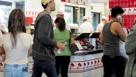 Crowd lining up to order and pick up at In-N-Out Burger location. Crew and cooks Stock Footage 97314796