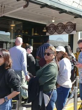 Crowd lining up outside the original Starbucks at Pike Place Market in Seat.. Stock Photos