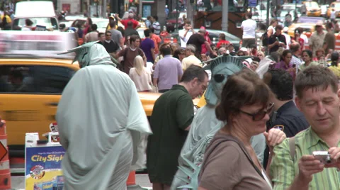 Crowd mills round 2 Statue of Liberty impersonators in sun glasses Stock Footage 39603843