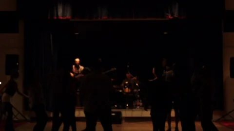 Crowd of party goers dance in a dark hall to a function band playing Stock Footage 107627369