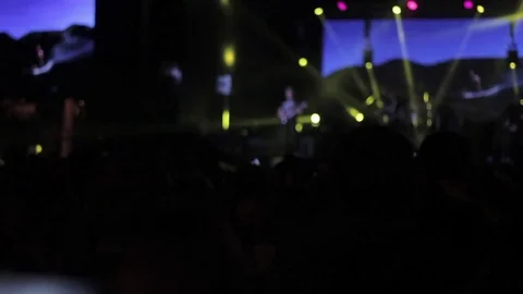 Crowd partying at a rock concert. Silhouetted hands and flashing lights. Slow Video stock 80351853