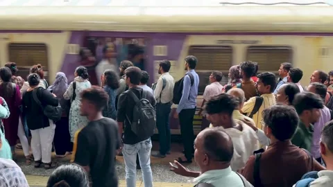 Crowd of passengers waiting on the platform as a train passes by in Mumbai Vídeo Stock 341455748