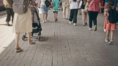 A crowd of passengers walk along the platform of the station near commuter Stock Footage 248366513