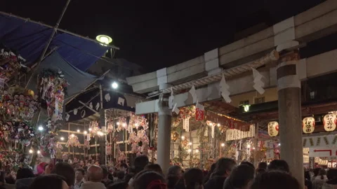 Crowd passing through the torii gate of Tori-no-Ichi Fair in Ootori shrine. Video stock 141965229