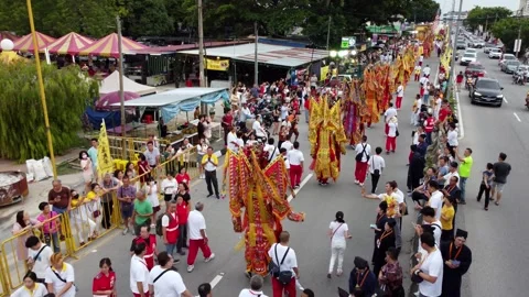 A crowd of people are walking down a street to view procession at street Видео 317006538