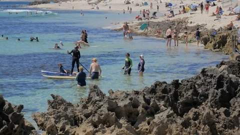 Crowd of people at the beach playing in the ocean Stock Footage 128039177