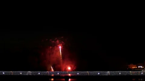 A crowd of people on the bridge watching a firework and celebrating a holiday. 库存影片 77153042