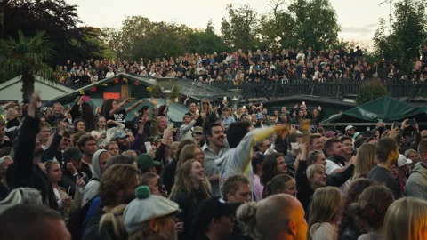 Crowd of people cheering and dancing at open air music concert in Christiania Stock Footage 344982988