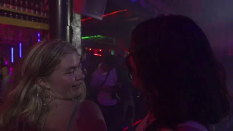 Crowd of people dancing under warm and neon lights in a nightclub 스톡 동영상 337470972