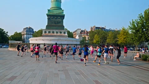 A crowd of people exercises doing cardio at the Colonne de Juillet square. Stock Footage 245457737