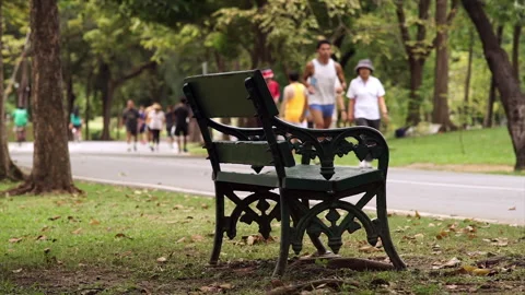 A crowd of people exercising and riding bikes through a lush park 動画素材 283707683