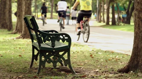 A crowd of people exercising and riding bikes through a lush park 動画素材 283710816