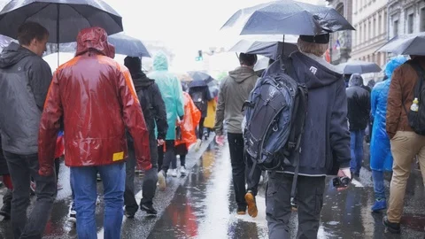 Crowd of people go to work in the rain with umbrellas Stock Footage 94591216