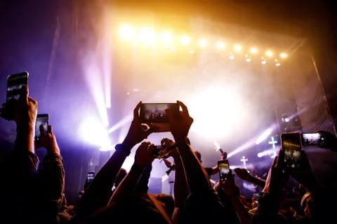 Crowd of people having fun while watching concert show at music festival. Rai Stock Photos