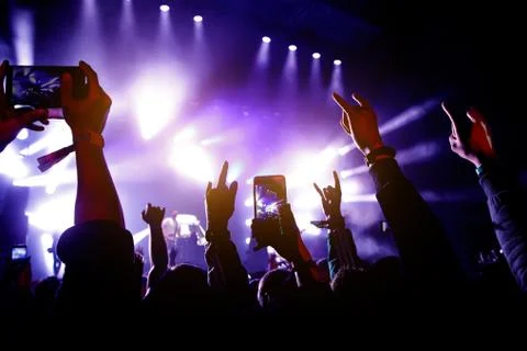 Crowd of people having fun while watching concert show at music festival. Rai Stock Photos