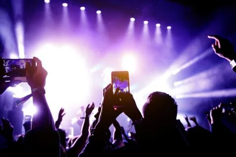 Crowd of people having fun while watching concert show at music festival. Rai Stock Photos
