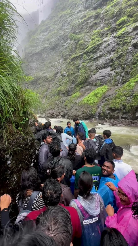 Crowd of people hiking in a river through a narrow rocky gorge in India Stock Footage 340252137