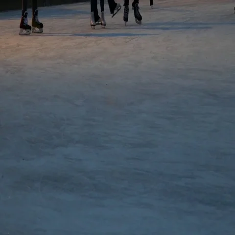 Crowd of people ice skating in different directions and a kid falls down on ice Stock Footage 69553195