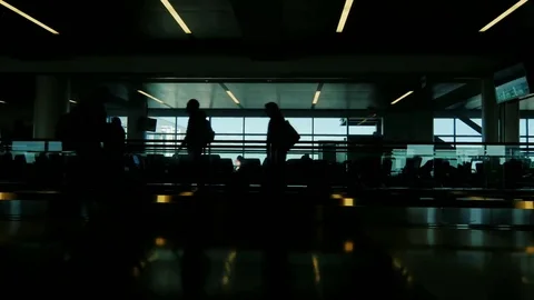 A crowd of people moved by a large JFK airport terminal in New York. Silhouettes Stock Footage 69275379