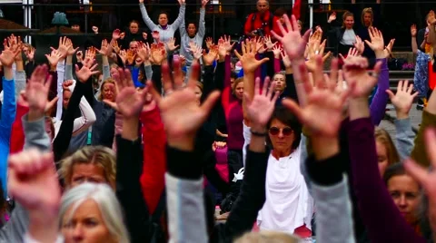 Crowd of people moving their hands up &amp; down breathing practice meditation yoga Stock Footage 63933586