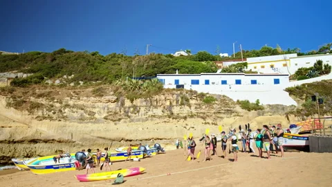 A crowd of people preparing to go kayak on the sea from the seashore in Algarve. Stock Footage 169661061