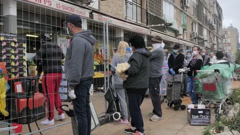 Crowd of people queuing outside shop wearing mask during covid epidemic, Stock Footage 131582976
