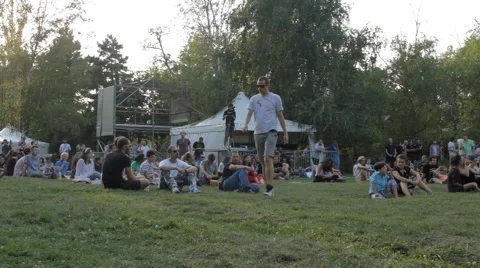 Crowd Of People Sitting On Grass In A Park Enjoying A Summer Festival Front Pan Stock Footage 41544053