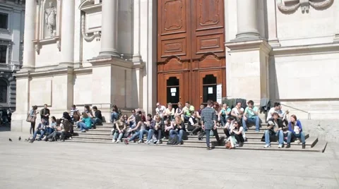 Crowd of People sitting on the steps of the Museum of San Fedele, Milan Stock Footage 63383160