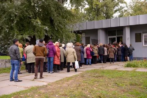 Crowd of people standing in a queue to enter to the building. Stock Photos