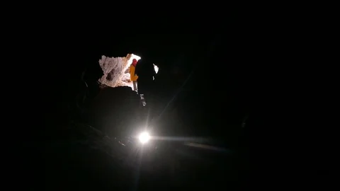 Crowd of people visiting a cave with their flashlights near the entrance Stock Footage 111682499