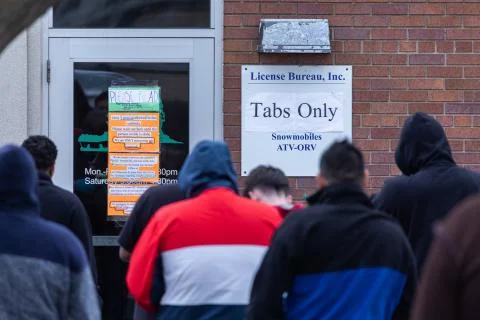 Crowd of people wait in line outside DMV Stock Photos