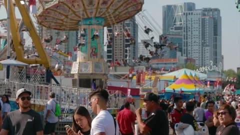 Crowd of people walk down a carnival midway during the summer Vidéo 195925053