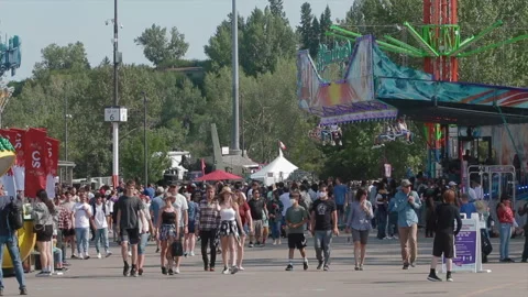 Crowd of people walk down a carnival midway during the summer Vidéo 195926352