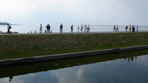 Crowd of people walking in between sea waters with their reflection on the water Stock Footage 104220707