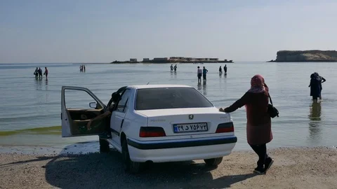 Crowd of people walking deep in the shallow sea waters to the nearby island Video stock 111667512