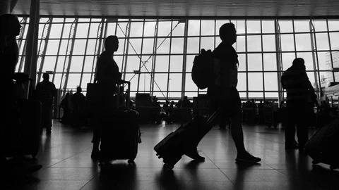 Crowd of people walking with luggage at airport terminal Silhouettes Stock Footage