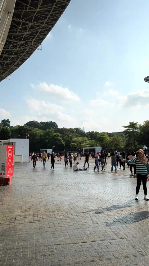 Crowd of people walking in public stadium plaza on a sunny day Stock Footage 340939098