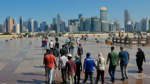 Crowd of People walking towards Doha downtown skyline and skyscrapers, Qatar Stock Footage 103946874