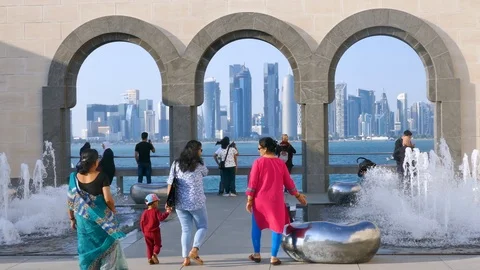 Crowd of people walking towards a viewpoint to center of Doha with skyscrapers Stock Footage 103947692