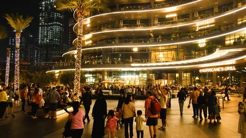 A crowd of people walks in the square in front of the Burj Khalifa tower  Stock Footage 125293096