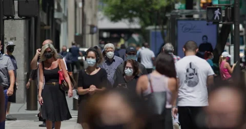 Crowd of people wearing mask masks walking street city coronavirus covid-19 Stock Footage