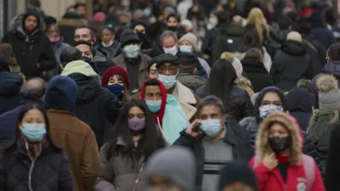 Crowd of people wearing mask masks walking street coronavirus covid-19 pandemic Stock Footage