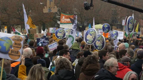 Crowd with protest signs representing small globes at Climate March. Amsterdam. Video stock 258043161