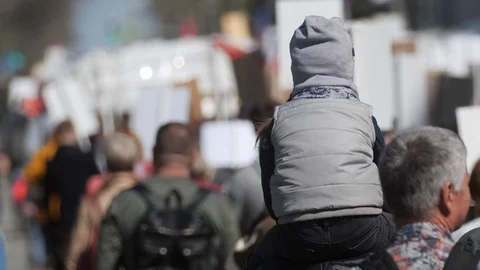A crowd of protesters go along banners with the kid on strike on a city street Stock Footage 121279273