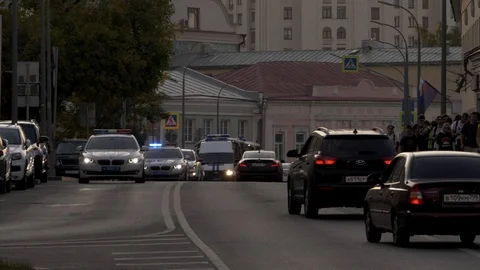 A crowd of protesters marching around the city,accompanied by police cars. Stock Footage 117538645