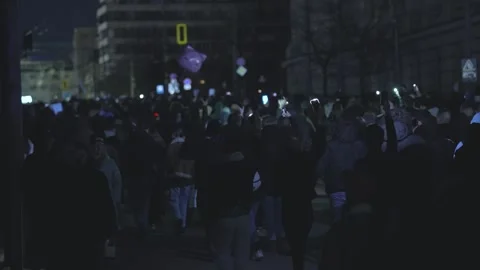 A crowd of protesters moves along a dark boulevard in central Sofia 스톡 동영상 324564004