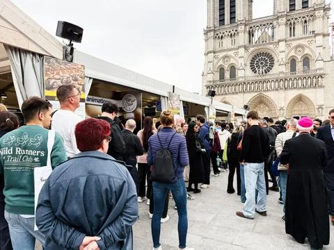 Crowd queuing at Notre-Dame cathedral street fair in Paris, France with tou.. 스톡 사진