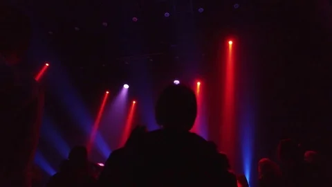 Crowd at rave party, people dance in blue light of projectors Video stock 70138491