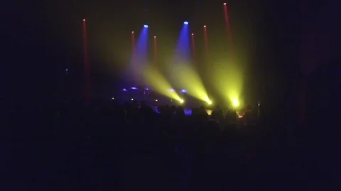 Crowd at rave party, people dance in blue light of projectors Video stock 70138688